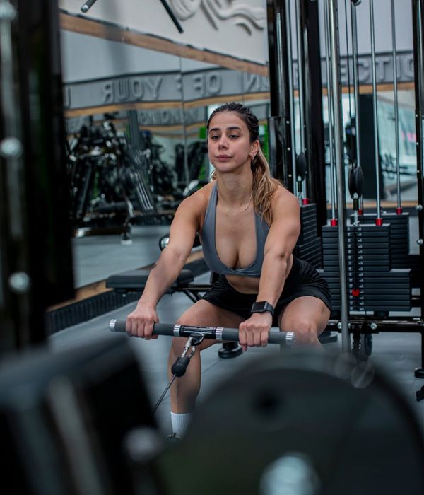 Professional athletic woman showing strength exercise in gym environment.